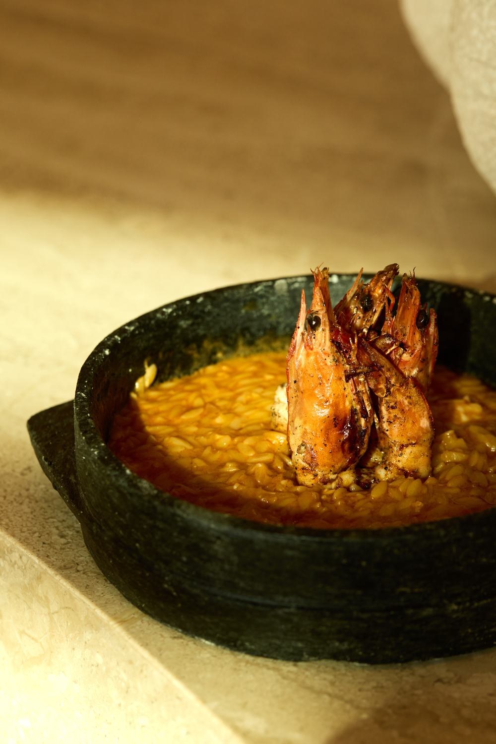 dāwa prawns on rice in a stone dish