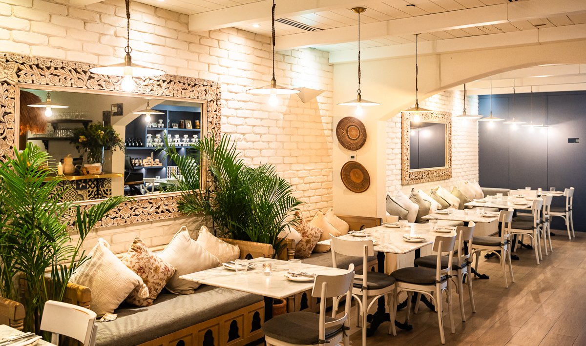 Villa Mamas Abu Dhabi white brick dining room with carved mirrors and banquettes