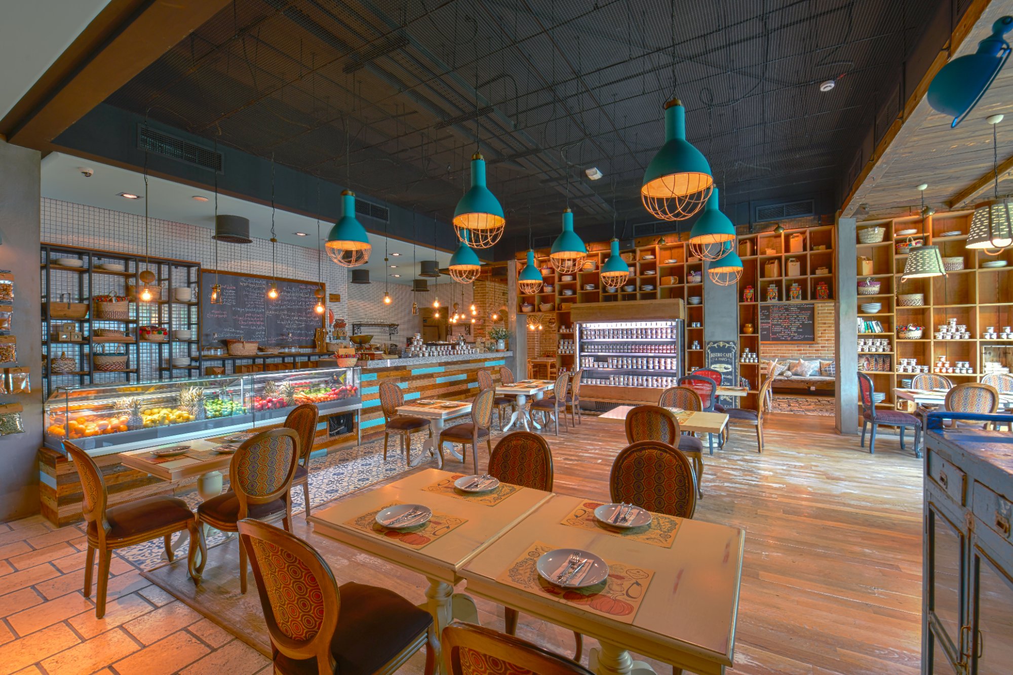 Villa Mamas Bahrain cafe with teal pendant lamps, deli counter and pantry shelves