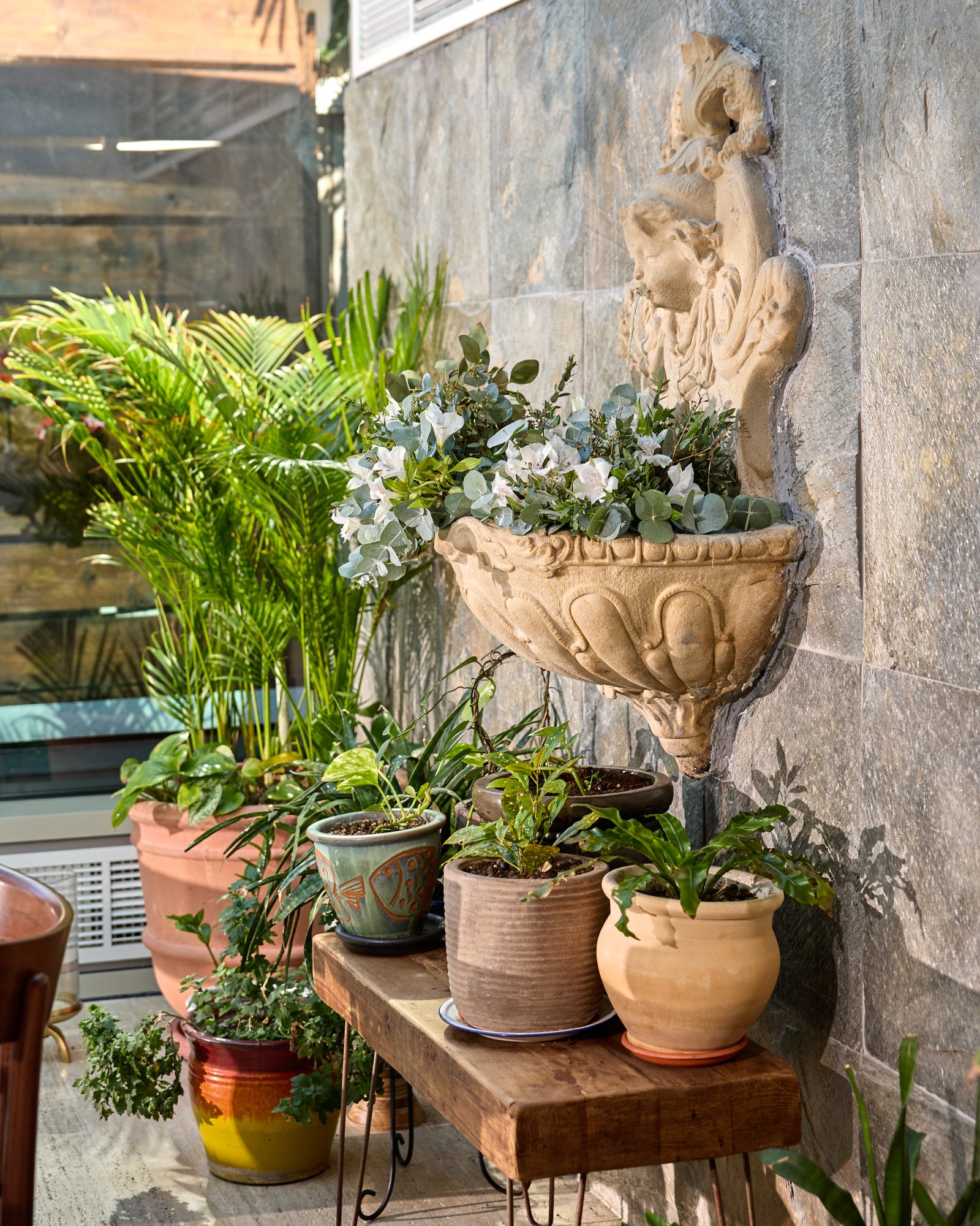Villa Mamas Bahrain stone fountain wall with potted plants