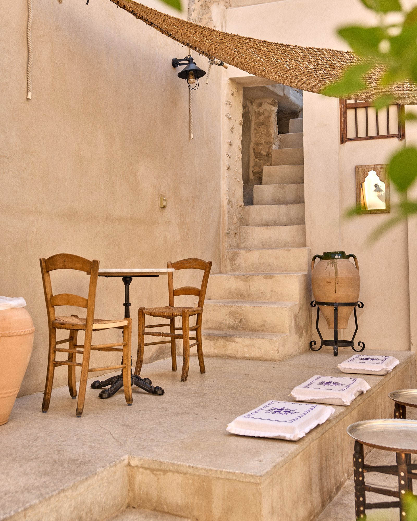 Bait Nasser courtyard with wooden chairs, marble table and stone staircase