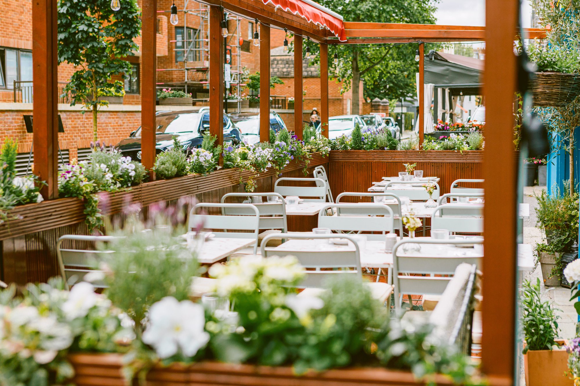Villa Mamas London garden terrace with marble tables and flower boxes