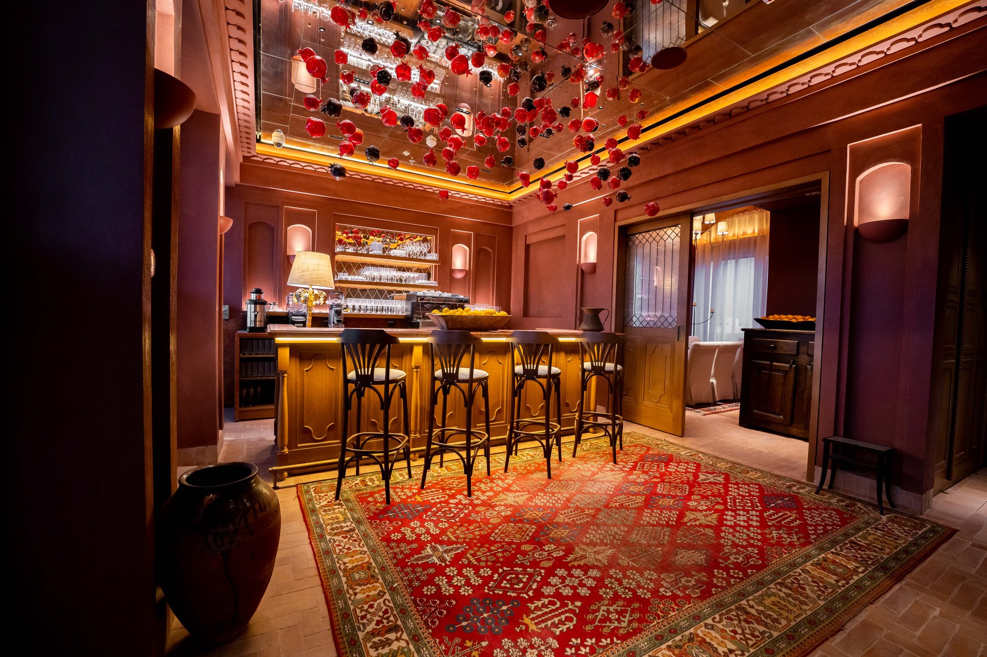 Villa Mamas Riyadh bar with red patterned rug and bentwood stools